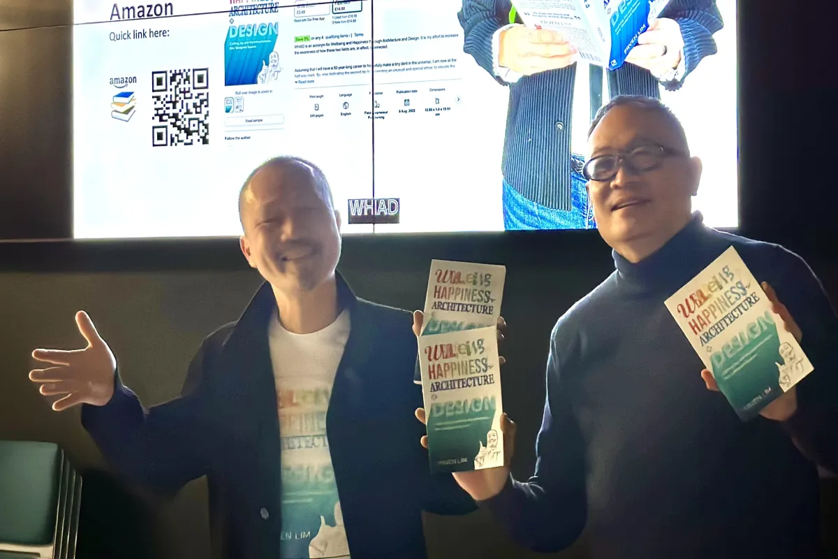 Frven with colleague at University of Huddersfield holding Happiness Architecture books during academic lecture