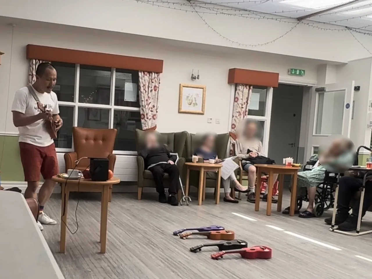 HappierMusic session by The Ministry of Happier — elderly residents seated and singing together in a care home activity room, North London
