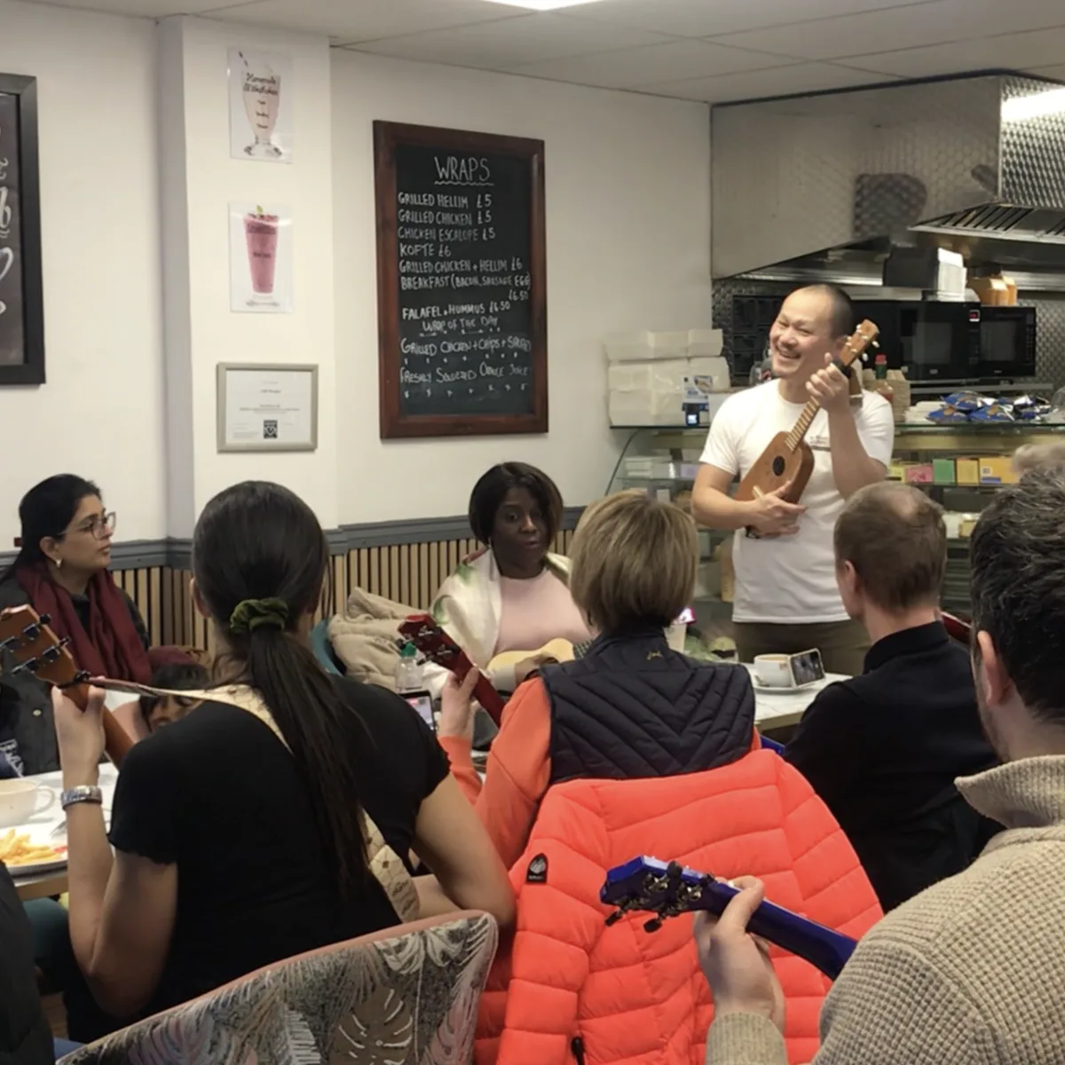 Adults and children learning ukulele together at a HappierMusic workshop